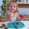 young girl plays with shells