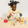 girl playing with earth pebbles and dolls