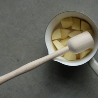 masher shown with potato in saucepan