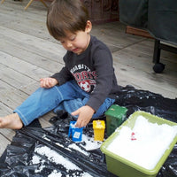 child playing with tub of snow