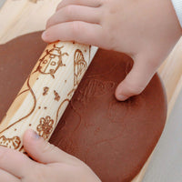 rolling pin shown with child's hands and dough