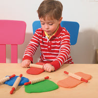 Boy rolling playdough with patterned rolling pin