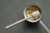 masher shown with potato in saucepan
