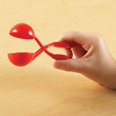 Red tweezers shown in child's hand