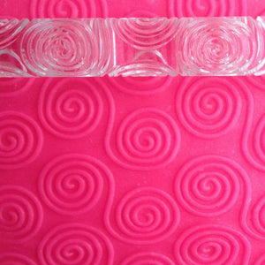 rolling pin with swirly patterns in pink playdough